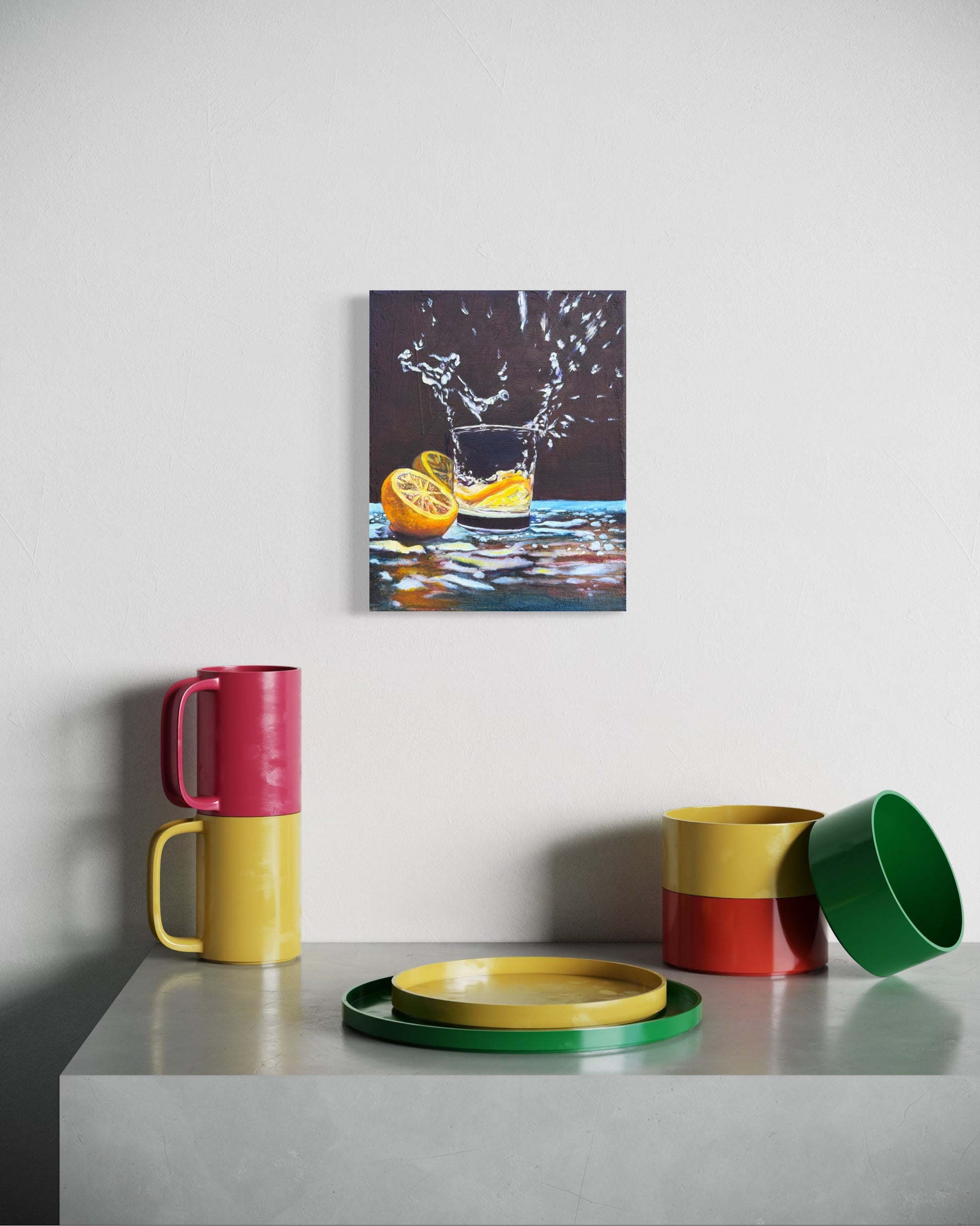 Colorful mugs and a bowl on a table with a painting of an lemon sliced and water splashing out of glass.