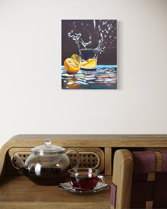 Tea set on a wooden table with an oil painting of a lemon splashing into a cup of water hung on the wall above.