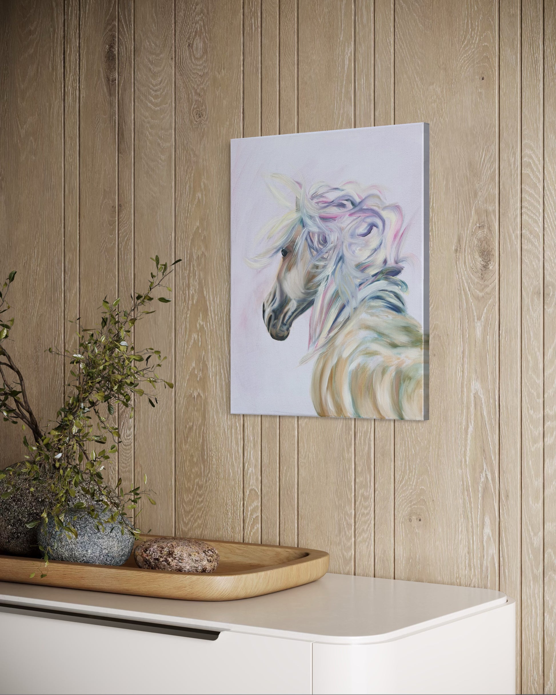 Colorful main on white horse oil painting on a wooden wall above a white cabinet with decorative items.